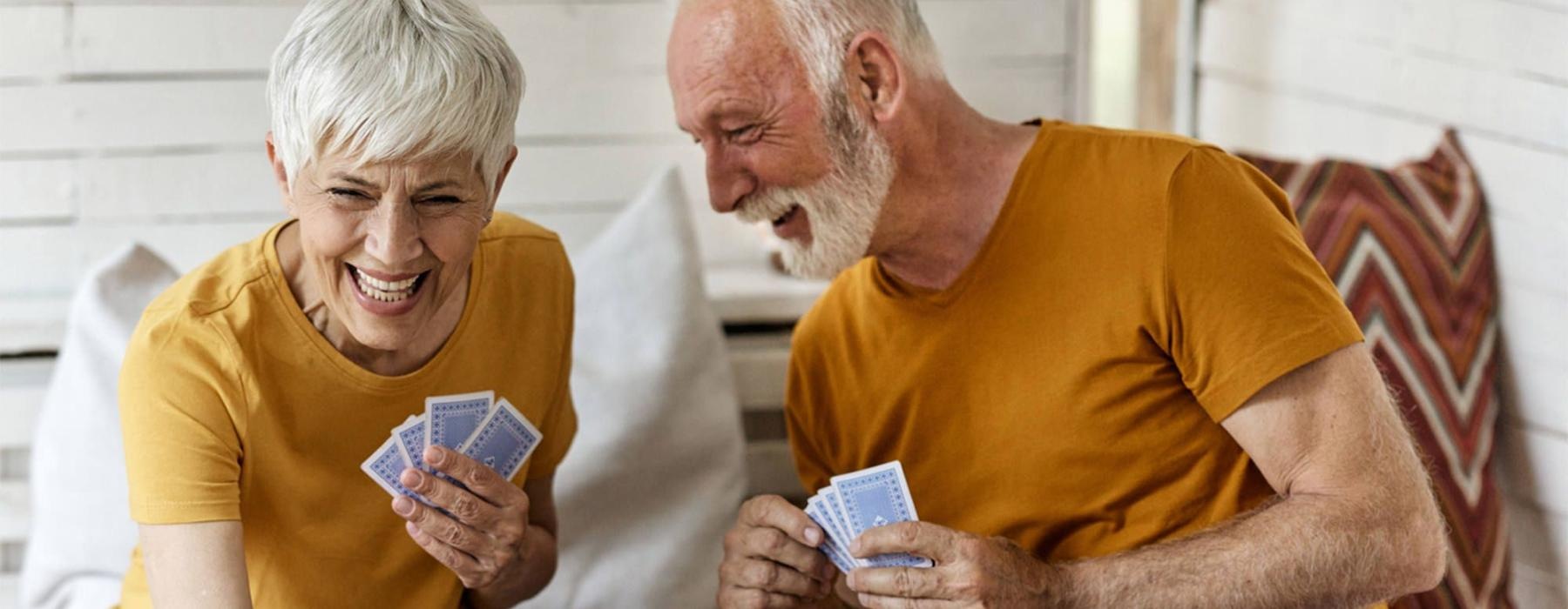 a man and woman sitting at a table playing cards